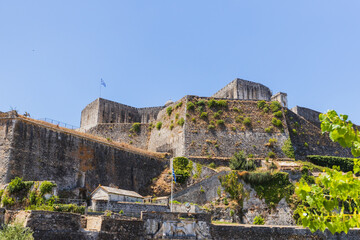 The imposing stone walls of the historic Old Fortress of Corfu, a Venetian landmark, stand against...