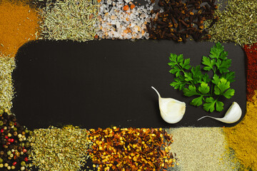 Frame made with different spices on dark background, flat lay. Space for text