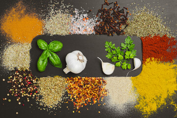 Frame made with different spices on dark background, flat lay. Space for text