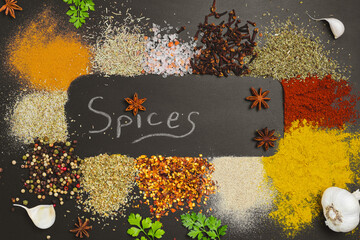 Frame made with different spices on dark background, flat lay. Space for text