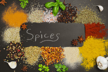 Frame made with different spices on dark background, flat lay. Space for text