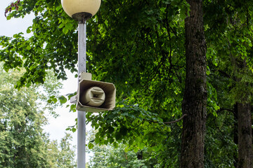Outdoor Loudspeaker on a Pole Surrounded by Greenery