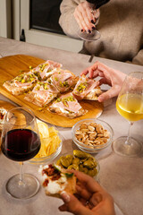 At a lively bar table, unseen guest enjoy food and drinks—cocktail, pinsa, and small bites fill the scene with flavor, conviviality, and Italian aperitivo vibes.