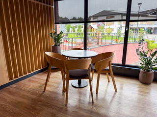 Restaurant interior with wooden chairs, and table set for guests. Dining, hospitality, and social atmosphere arranged for comfort, leisure, and service.