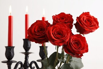 Elegant arrangement of red roses with candles for romantic settings