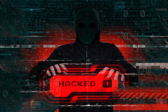 Masked hacker behind a computer with a red warning Hacked. Concept of cybersecurity threat, attacks on data and online systems.