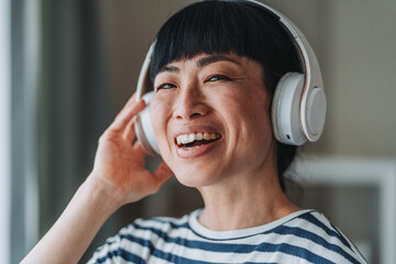 Happy woman listening to music with headphones and smiling
