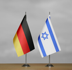 Tabletop flags of Germany and Israel on stands on a gray blurred background
