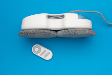 Modern Robotic Floor Cleaner with Remote Control on Vibrant Blue Background