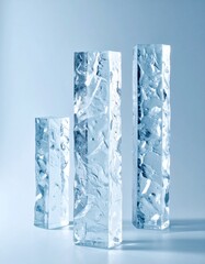 Three Ice Hexagonal Prism Columns Arranged Vertically on a Soft Blue Background in Studio Lighting