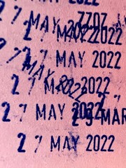 Dater Stamp blue marks with dates and years from stamped on pink paper background.