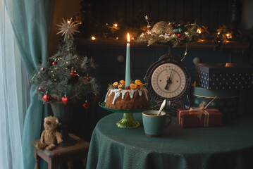 Vintage Christmas cake with candle gifts and festive lights near tree