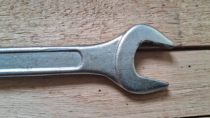 Close-up of a Metal Open-Ended Wrench on a Wooden Surface