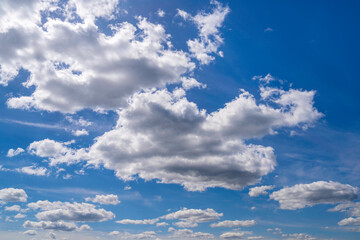 White summer clouds in the blue sky, forming abstract geometry and organic shapes, an aerial cloudscape for backgrounds