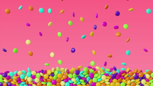 Colorful candy dragees endlessly falling and filling the screen on pink background