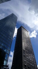 Obraz premium Two skyscrapers against a partly cloudy sky