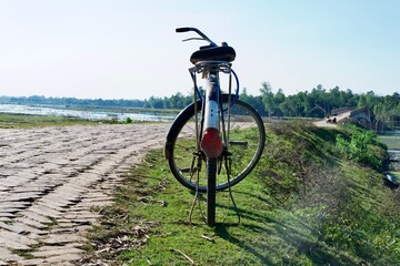 Bicycle on the road with green grass field background 