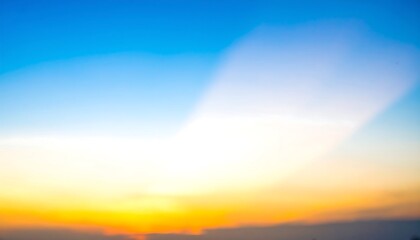 Obraz premium A beautiful sunset sky displays soft, blended colors of orange, yellow, and blue.