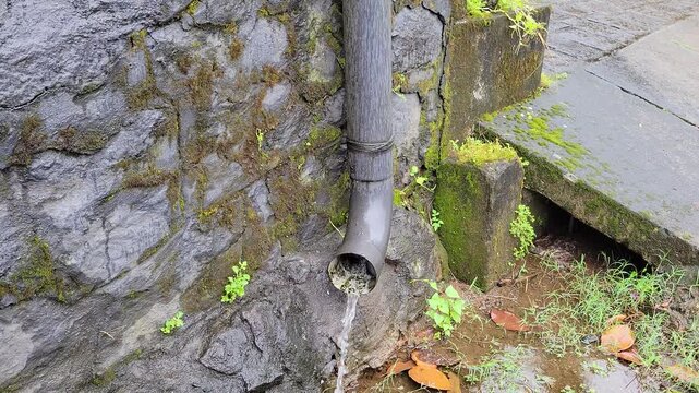 Drainage pipe fixed toward a tar road, designed for channeling rainwater and wastewater from urban infrastructure