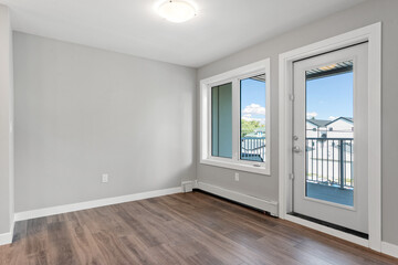 Large open room with a white wall and wooden floors