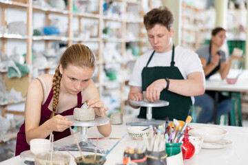 Pottery lesson - teenagers intently create dishes from clay