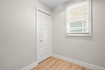 White door with a white door knob sits in front of a window