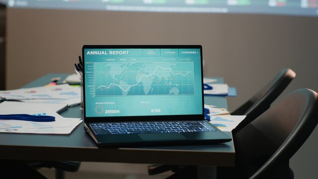 Modern corporate space sits empty after hours with forecasting charts and business analytics displayed across the wall. Capturing the late night management and planning event. Project insight.