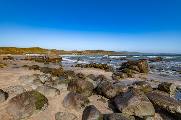The serene coastal landscape of Cachagua, Chile, showcasing large rocks on the sand and the Pacific Ocean.