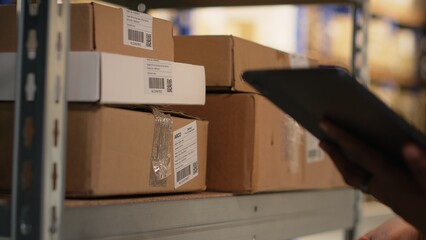 Black female worker using scanner checking airway bill numbers in inventory, solving logistics...