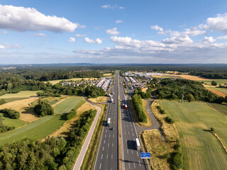 Aerial view of a9 highway near Pegnitz, Bavaria, Germany. Trucks on road amid fields and forests...