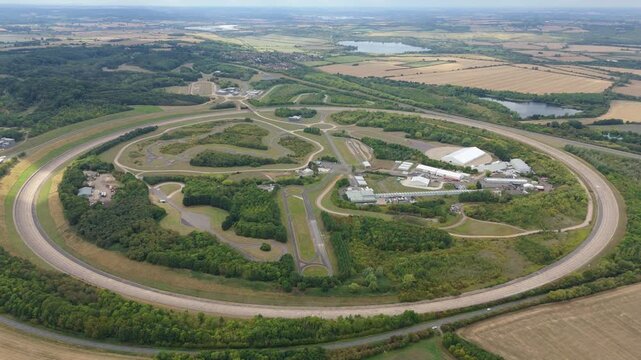 Aerial drone view of motorsports race track, sharp bends and straights, circular arena, vehicle testing facility proving ground near Bedford England UK