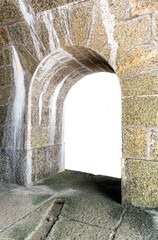 An old passageway with an arch built from large blocks of rustic, aged stone. Brazilian fortification, damp stains on the wall, and a damp rock floor. Isolated on a transparent background.