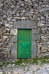 Old antiaue green door on a stone building in Provance, France.