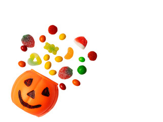 Halloween pumpkin bucket with smiling jack o lantern face filled with colorful gummy candies...