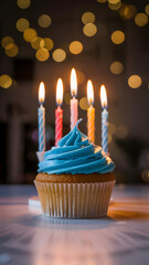 A frosted cupcake with candles, illuminated with bokeh background lights