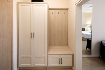 Entrance area of a hotel room with a brown wooden decorative wall