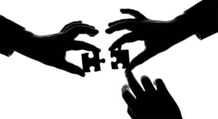 Silhouetted hands connecting puzzle pieces, symbolizing teamwork and collaboration.
