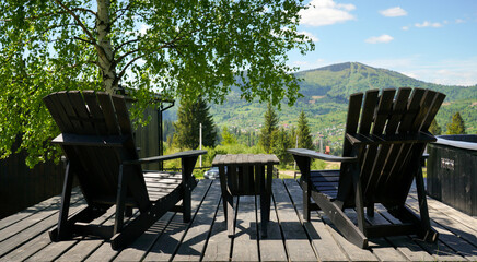 Black wooden outdoor furniture on a patio with mountain view