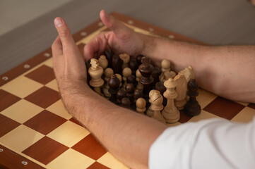 Close up of hands of middle aged caucasian man playing chess. 