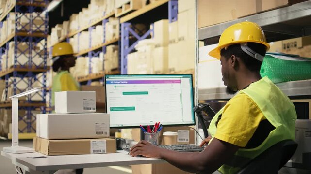 Black depot clerk reviewing inventory data on tracking software for distribution system, busy logistics hub stock room with organized racks. Online retail fulfillment and supply chain. Camera A.