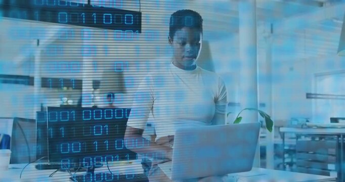 Developer opening laptop and typing code in office, causing binary overlay scrolling across frame