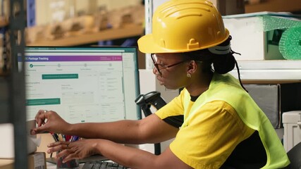 Black worker applying and scanning barcodes awb tags on cargo boxes, registering the merchandise and shipment details before distribution. Using scanner on tracking numbers in depot. Camera B. - Powered by Adobe