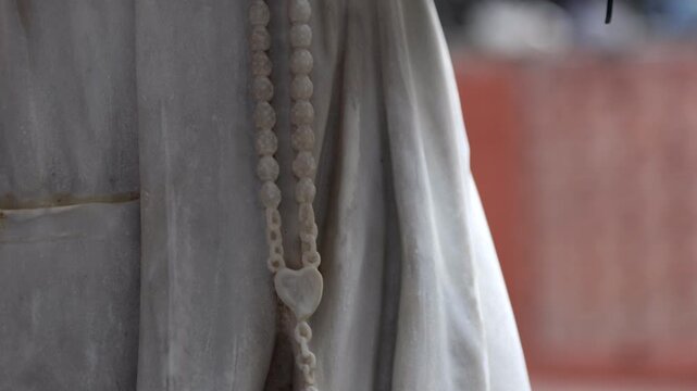Estatua cat&oacute;lica sosteniendo un rosario con la mano