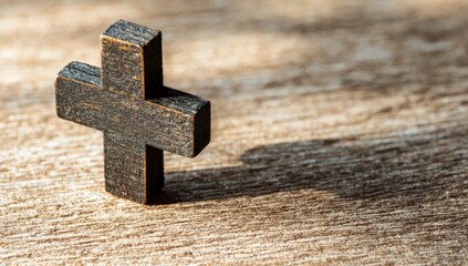 Dark wooden cross on light wood