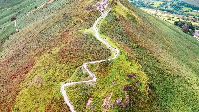 aerial close up drone shot flyover of catbells mountain in Lake District England surrounded by nature and valleys in summer with cloudy skies