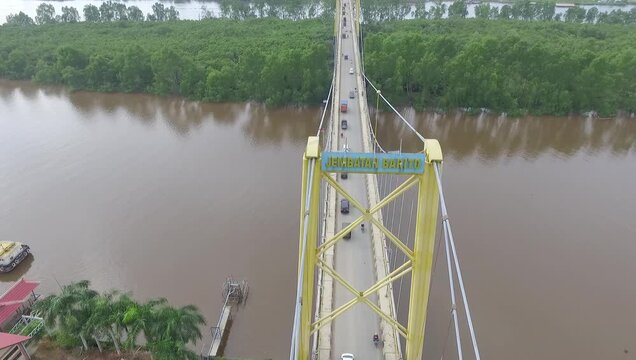 Aerial video of the magnificent beauty of the Barito Bridge supported by the beautiful Bakut Island Tourism Park Land.