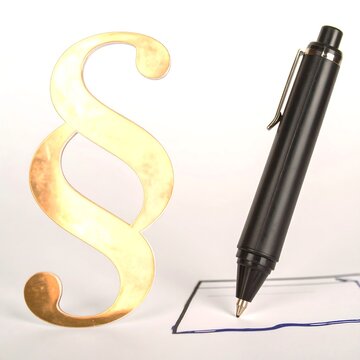 Gold paragraph symbol and pen on paper