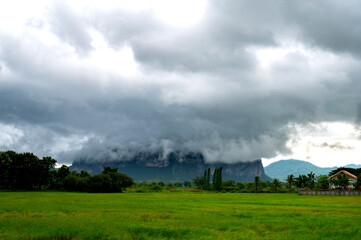 Super storm with sun light , Dark sky and dramatic black cloud before rain.rainy storm over rice...