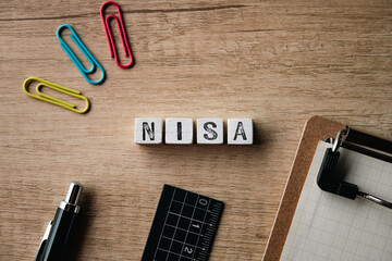 There is wood cube with the word NISA. It is an abbreviation for Nippon Individual Savings Account as eye-catching image.