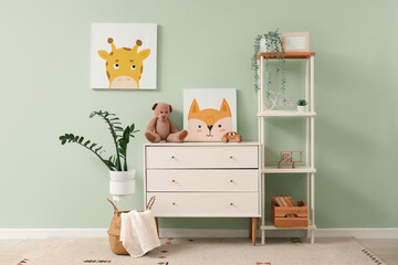 Interior of nursery with commode, shelf unit and pictures
